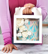 Woman holding a cake in a 8x8x8 white paper cake box with window and handle