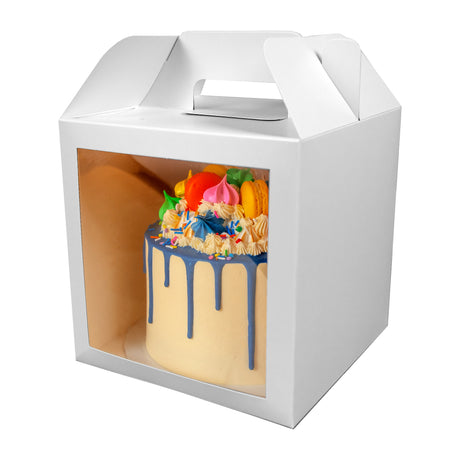 A cake in a 8x8x8 white paper cake box with window and handle