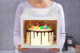 Woman holding cake in 10x10x8 white paper cake box with window and handle