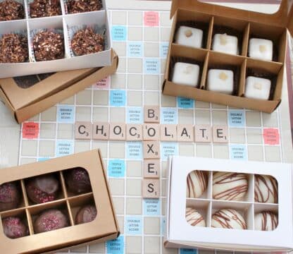 Mini treat boxes with windows and dividers set on a Scrabble board